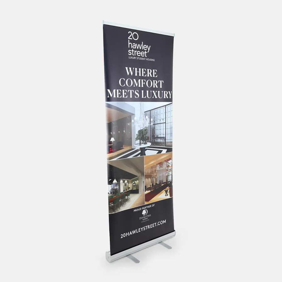 A real estate retractable banner printed with property images and Where Comfort Meets Luxury in white text.