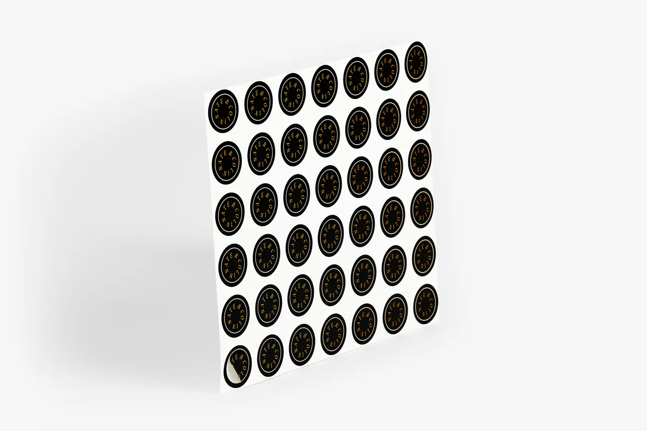 A sheet of custom sticker seals printed with a black background and Nate & Colin in gold.