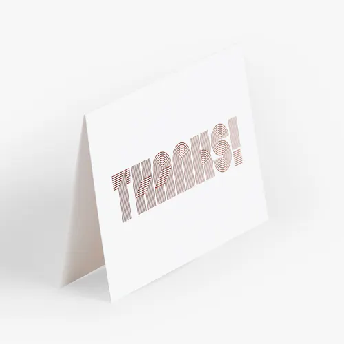 A thank you card printed with Thanks! on the front in a thick, striped font.