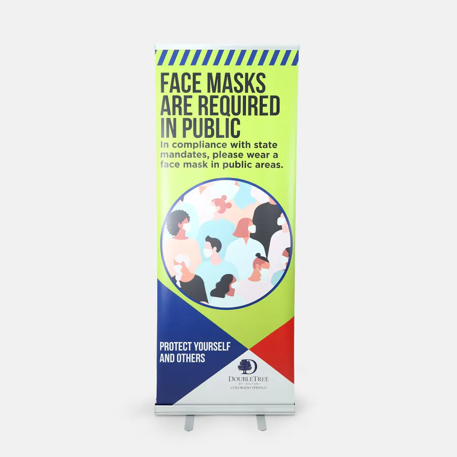 A retractable pop-up banner printed with Face Masks Are Required in Public and safety imagery.