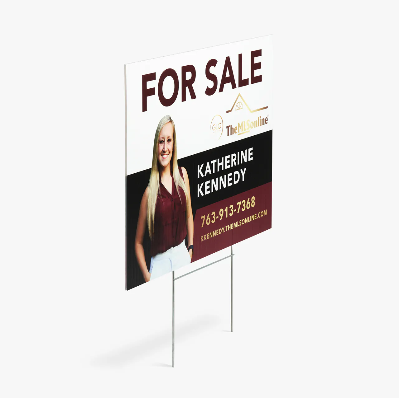 A yard sign printed with For Sale in dark red with an image of a smiling woman and Katherine Kennedy in white.