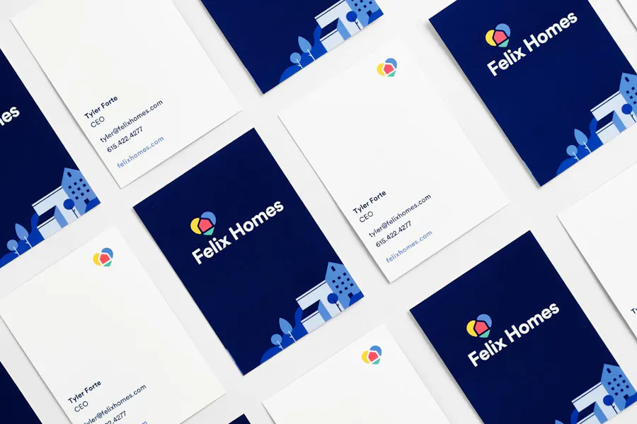 Real estate business cards lined up in rows with a blue design on the front and a white design on the back.