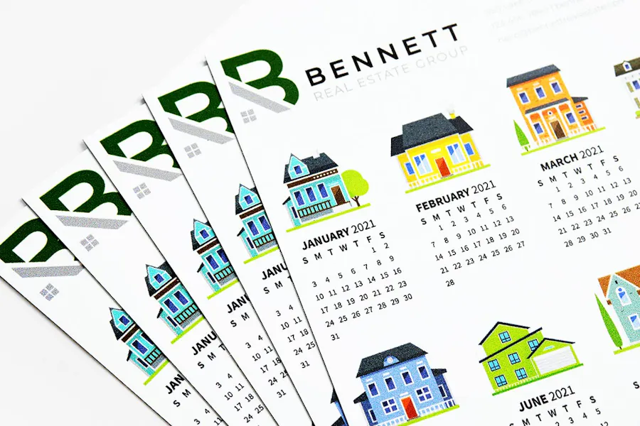 Five real estate calendar magnets fanned out with graphics of different properties for each month.