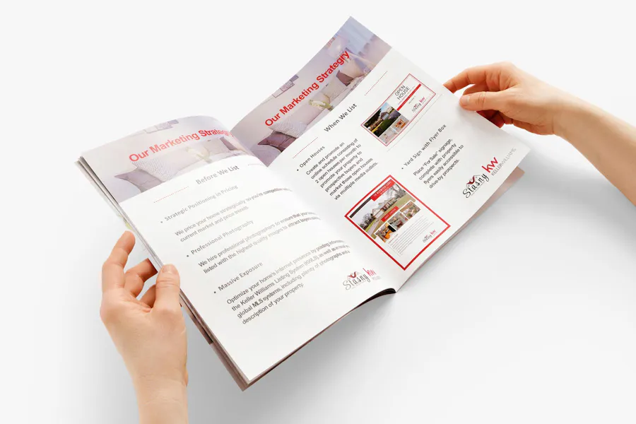 Two hands holding a real estate booklet open to pages printed with Our Marketing Strategy.