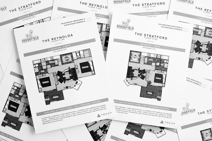 A collection of real estate flyers scattered on top of each other with floor plans and property information.