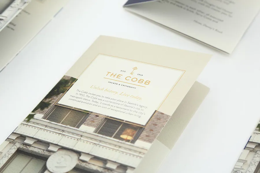 Real estate print marketing booklets with The Cobb in gold text and images of a rental property on the front.