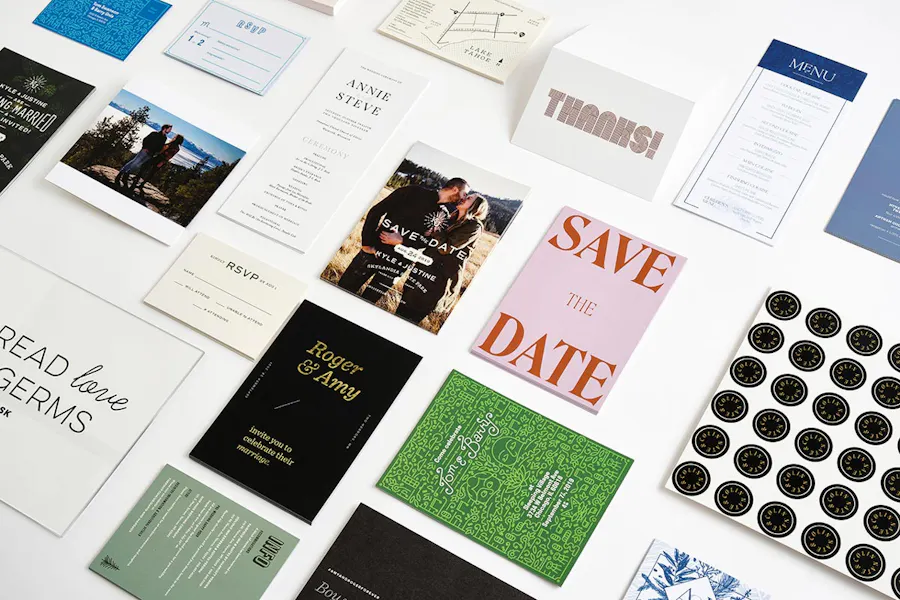 A group of custom printed wedding stationery, including save the dates, invitations, map cards, RSVPs and programs.