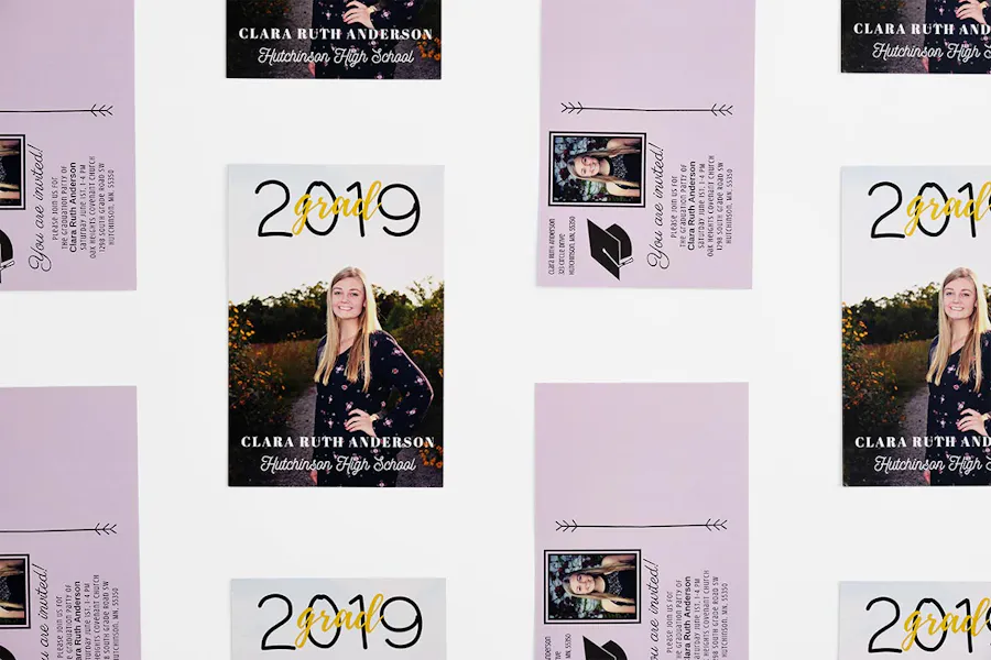 Custom graduation postcards lined up in rows, with a girl posing on the front and a light purple design on the back.