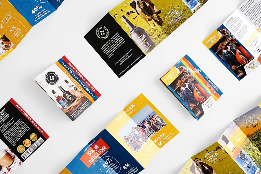 Multiple folded and unfolded stepped accordion marketing brochures lined up in rows.