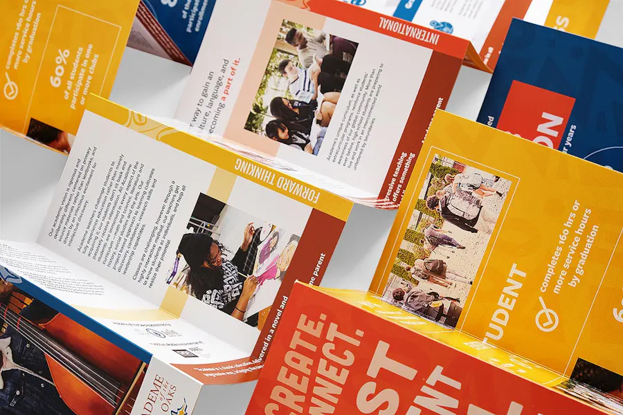 Three stepped accordion brochures unfolded with a bright yellow, red and blue design.