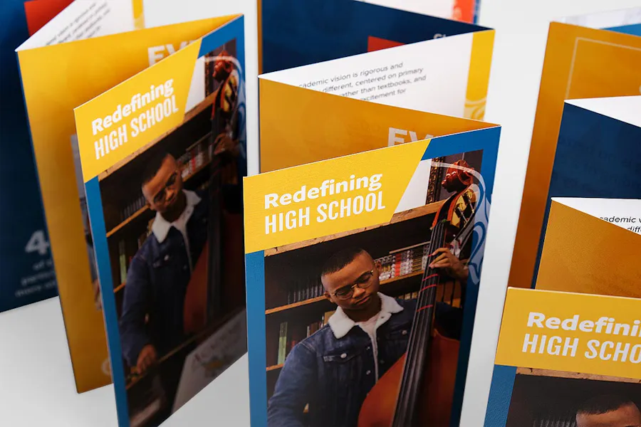 Four accordion fold brochures for a high school standing next to each other.