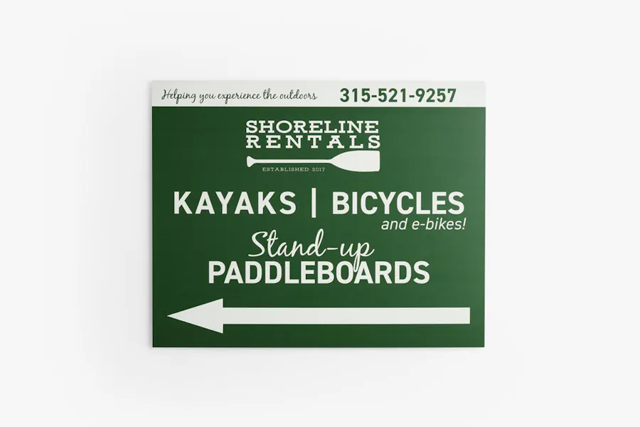 An aluminum sign for Shoreline Rentals with a green background and an arrow pointing to the left.