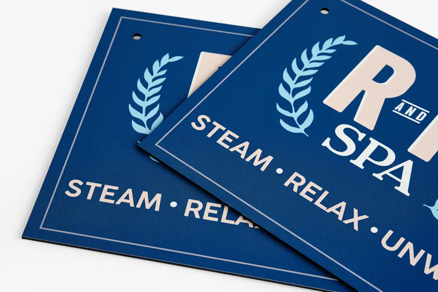 Two custom metal signs with a blue design overlapping each other.