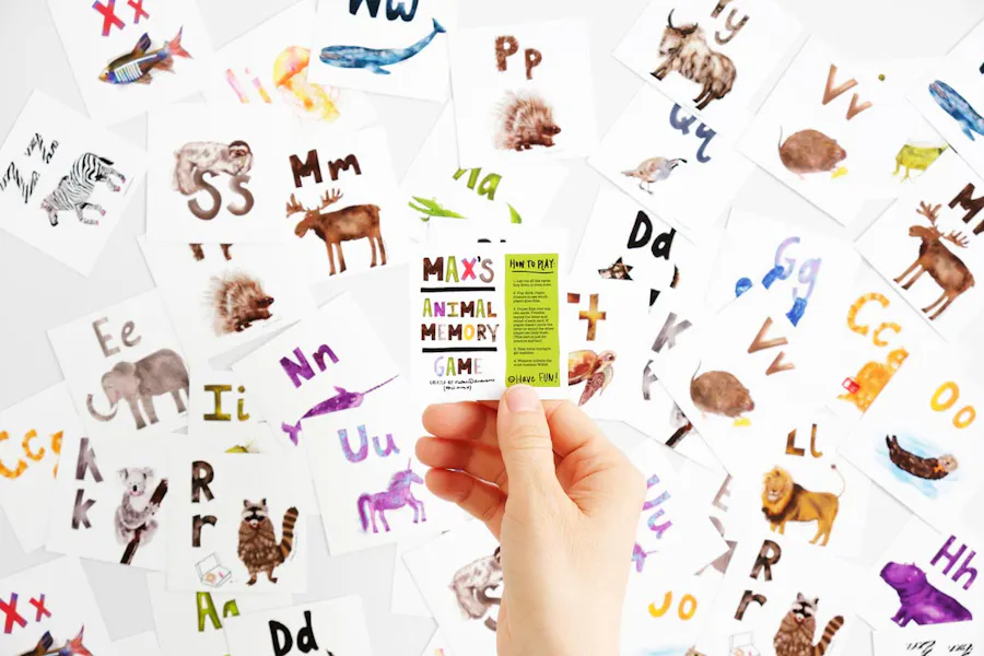 A collage of scattered memory flashcards with animals and letters and a hand holding the instructions card.