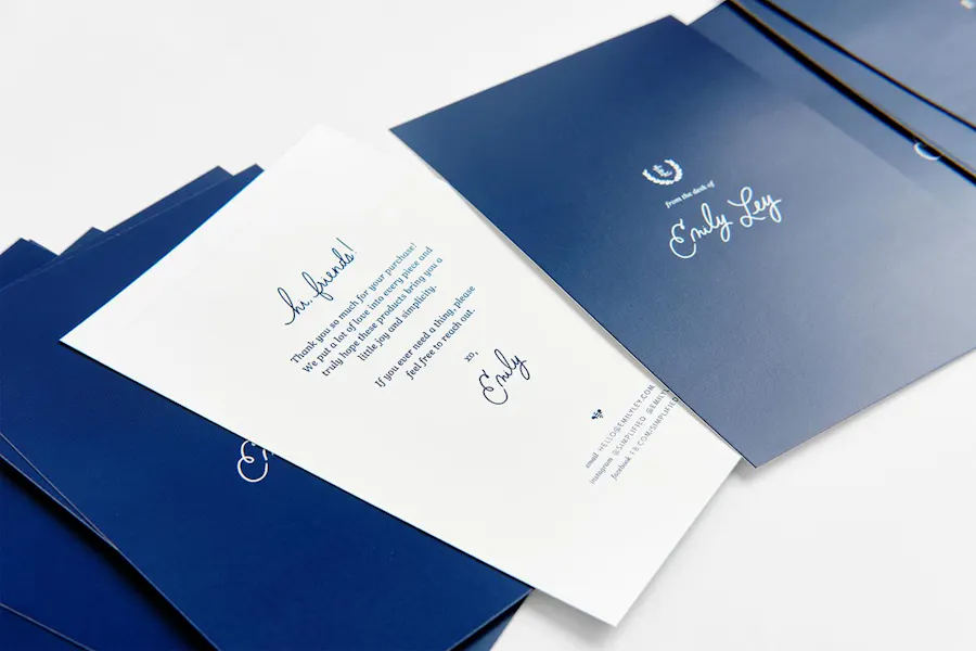 A row of fanned-out custom postcards designed as packaging inserts in navy blue and white.