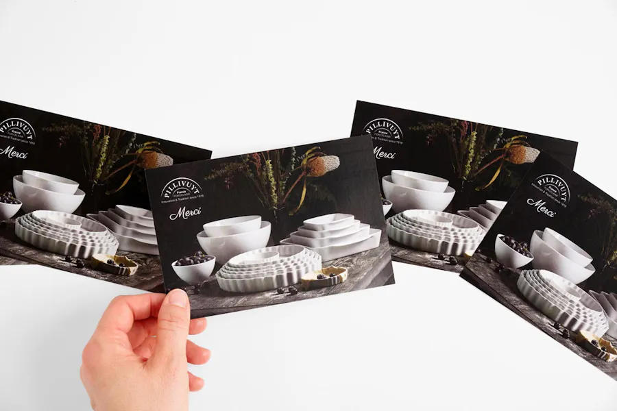 A row of four custom postcard inserts with a hand holding the second one.