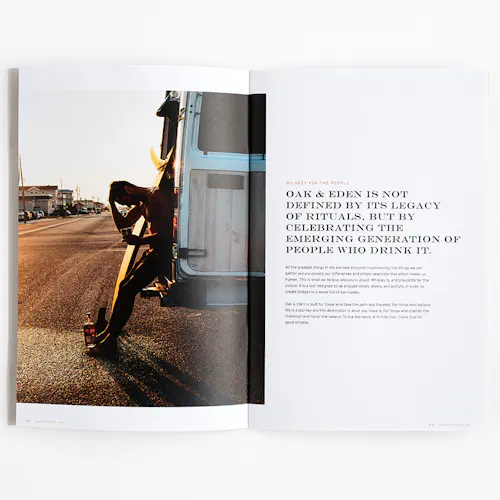 An Oak & Eden marketing booklet laying open to an image of a surfer leaning against his vehicle.