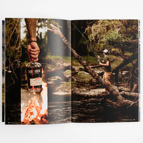 An Oak & Eden marketing booklet laying open to images of a man fishing and a hand holding a whiskey bottle.