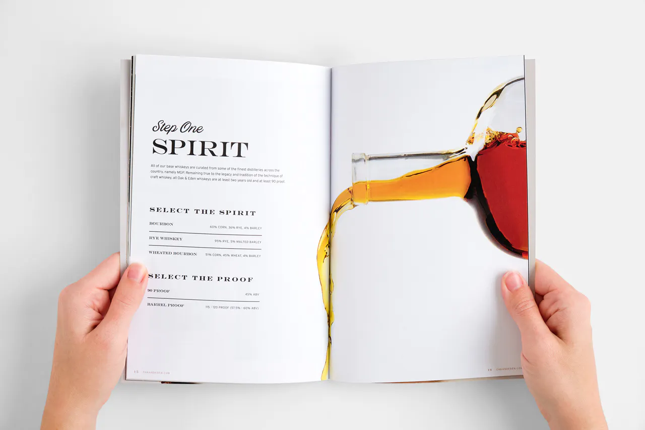 Two hands holding a marketing booklet open with an image of a bottle pouring whiskey and loyalty program details.