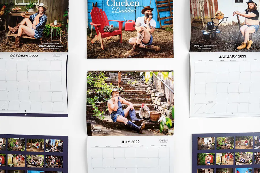 Six custom wall calendars lined up and printed with Chicken Daddies in white and men posing with their chickens.