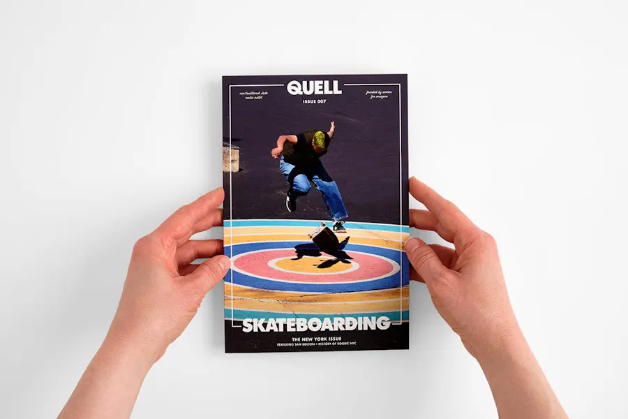 Two hands holding a custom booklet with a perfect binding and a person skateboarding on the cover.
