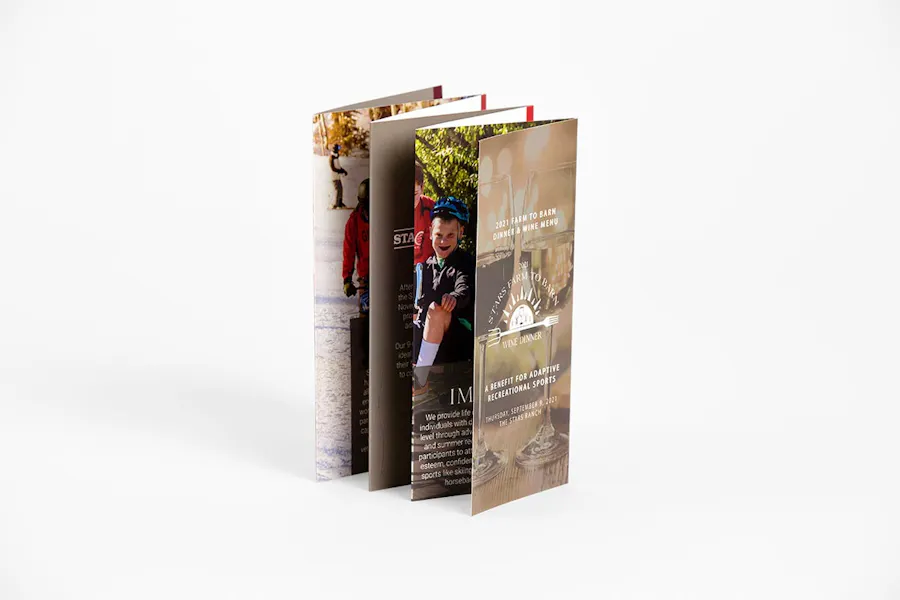 A stepped accordion brochure printed with A Benefit for Adaptive Recreational Sports standing open.