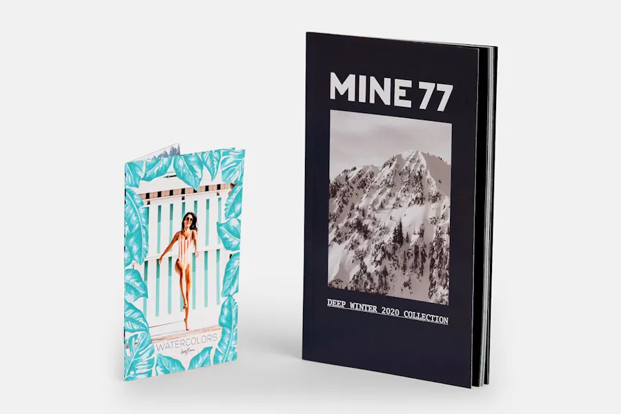 The Burton Mine77 product lookbook standing next to a product brochure with a woman in a swimsuit on the cover.