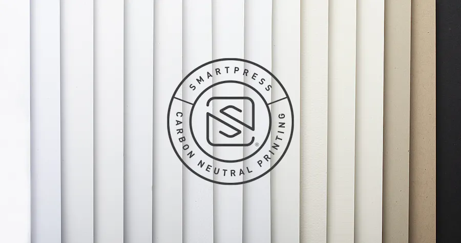 The Smartpress Carbon Neutral Printing logo over fanned-out paper stocks with neutral colors from white to black.