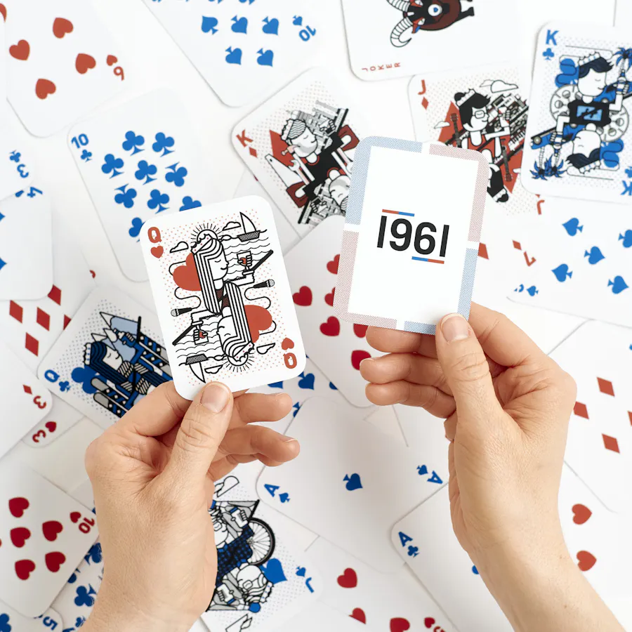 Two hands holding custom playing cards printed with 1961 and blue and red color.