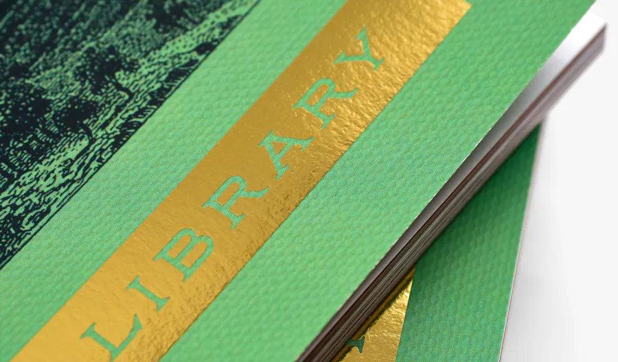 Two booklets stack on top of each other printed with green covers and gold foil accents.