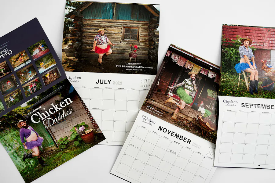 Four Chicken Daddies wall calendars laying open to different months.