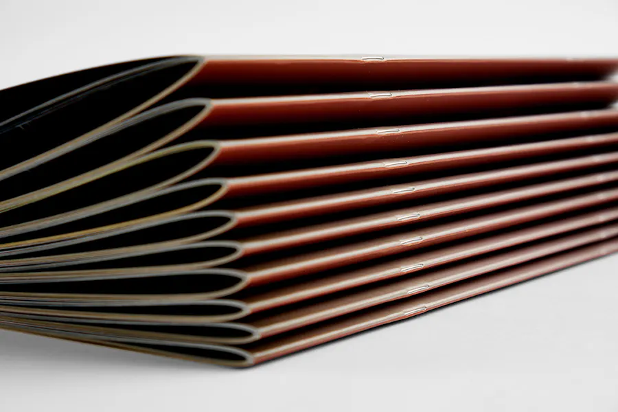 A stack of 10 calendars with saddle stitched binding.