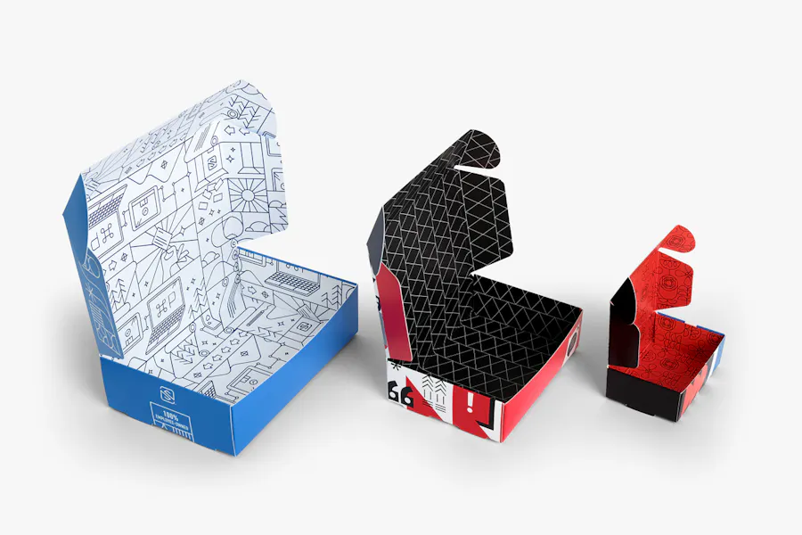 Three roll end boxes in different sizes lined up in a row with blue, white, red and black designs.