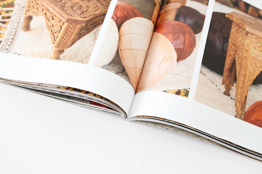 A product catalog printed with a perfect binding laying open to images of furniture.