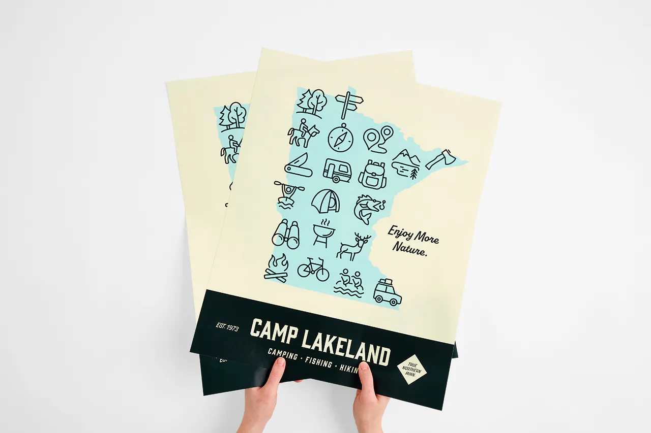 Two hands holding custom wall decals printed with the shape of Minnesota and Camp Lakeland.