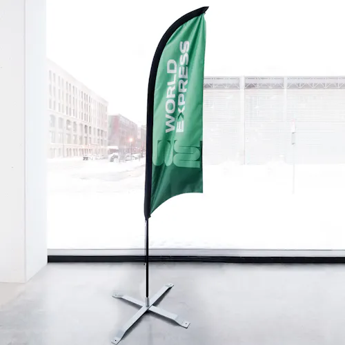 A trade show feather flag printed with a green design and World Express.