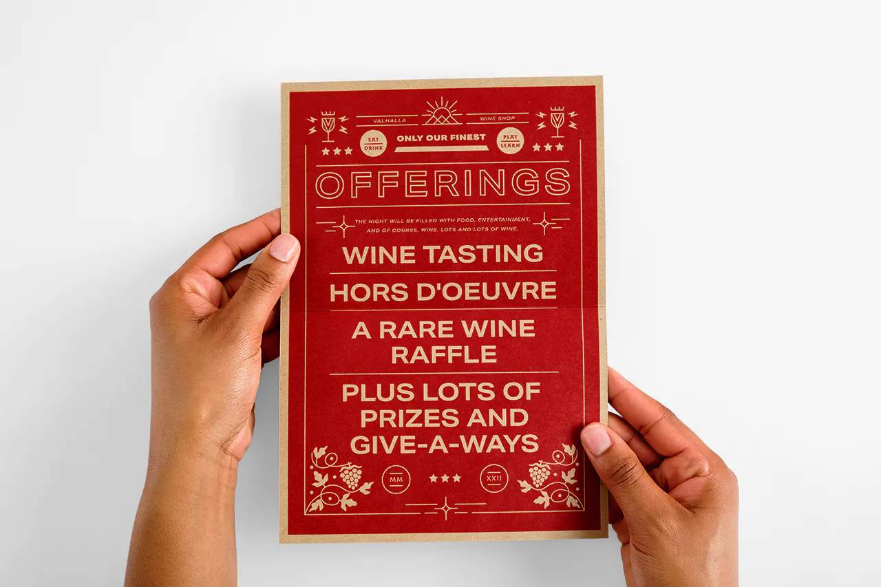 Two hands holding an invitation printed on Kraft paper with food and drink offerings.