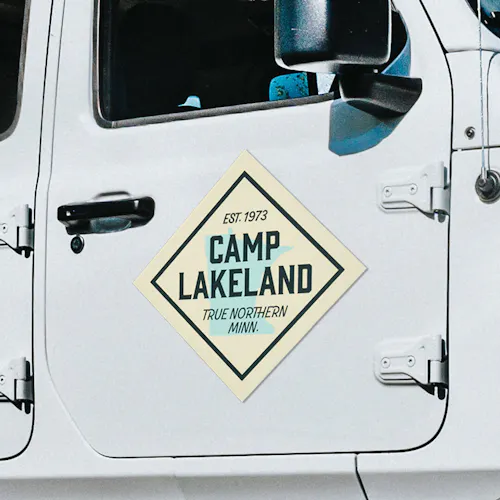 A car magnet on a white jeep printed with Camp Lakeland Est. 1973.