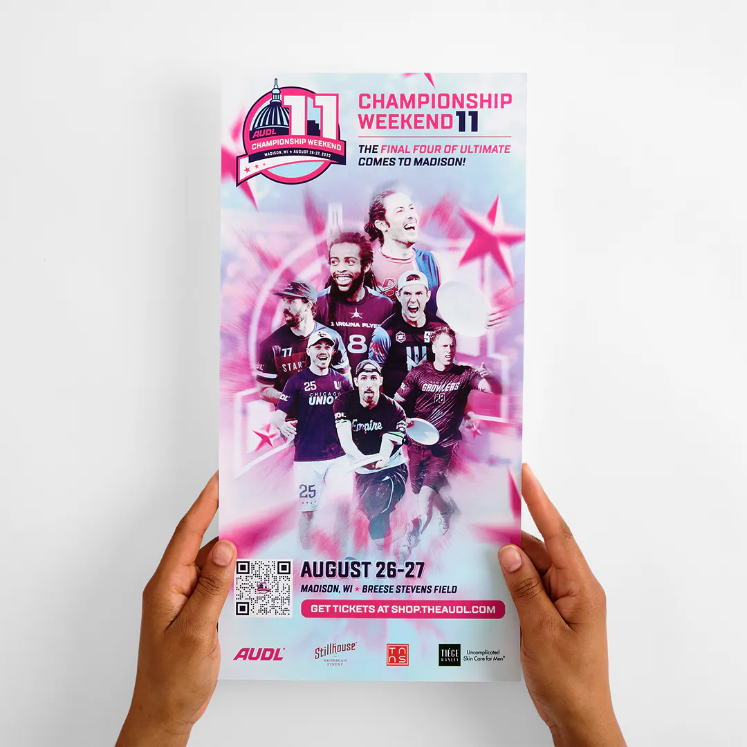 Two hands holding a custom poster printed with a blue, white and pink design, images of ultimate disc players and details about championship weekend.