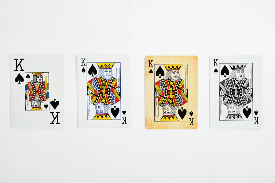 Four King playing cards lined up in a row with various designs, including enlarged letters, and a vintage sepia background.