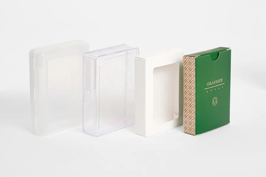 Four custom playing cards packaging options lined up in a row, including two clear cases, a white window box and a green box.
