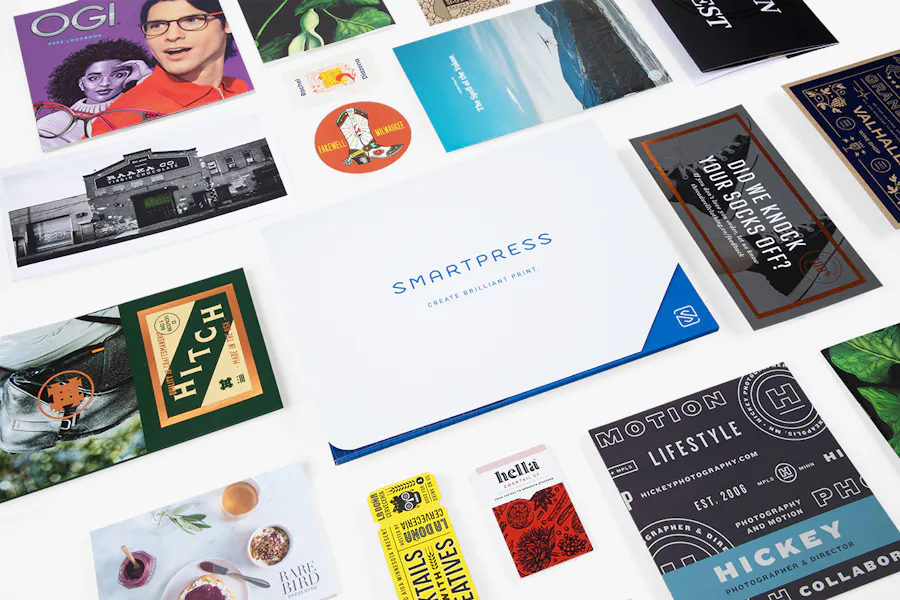 Various print marketing materials lined up in rows, including a Smartpress folder, booklets, postcards, event tickets and more.