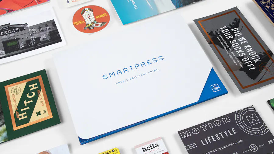A Smartpress branded folder printed with a blue and white design surrounded by various print marketing pieces.