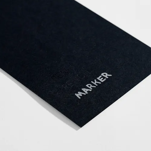 UNCOATED BLACK Uncoated black paper stock with pen, pencil and marker written on it.