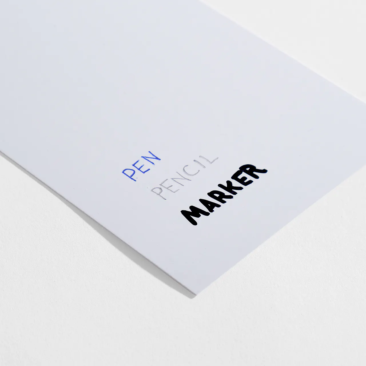 Coated 1-sided semigloss paper stock with pen, pencil and marker written on it.