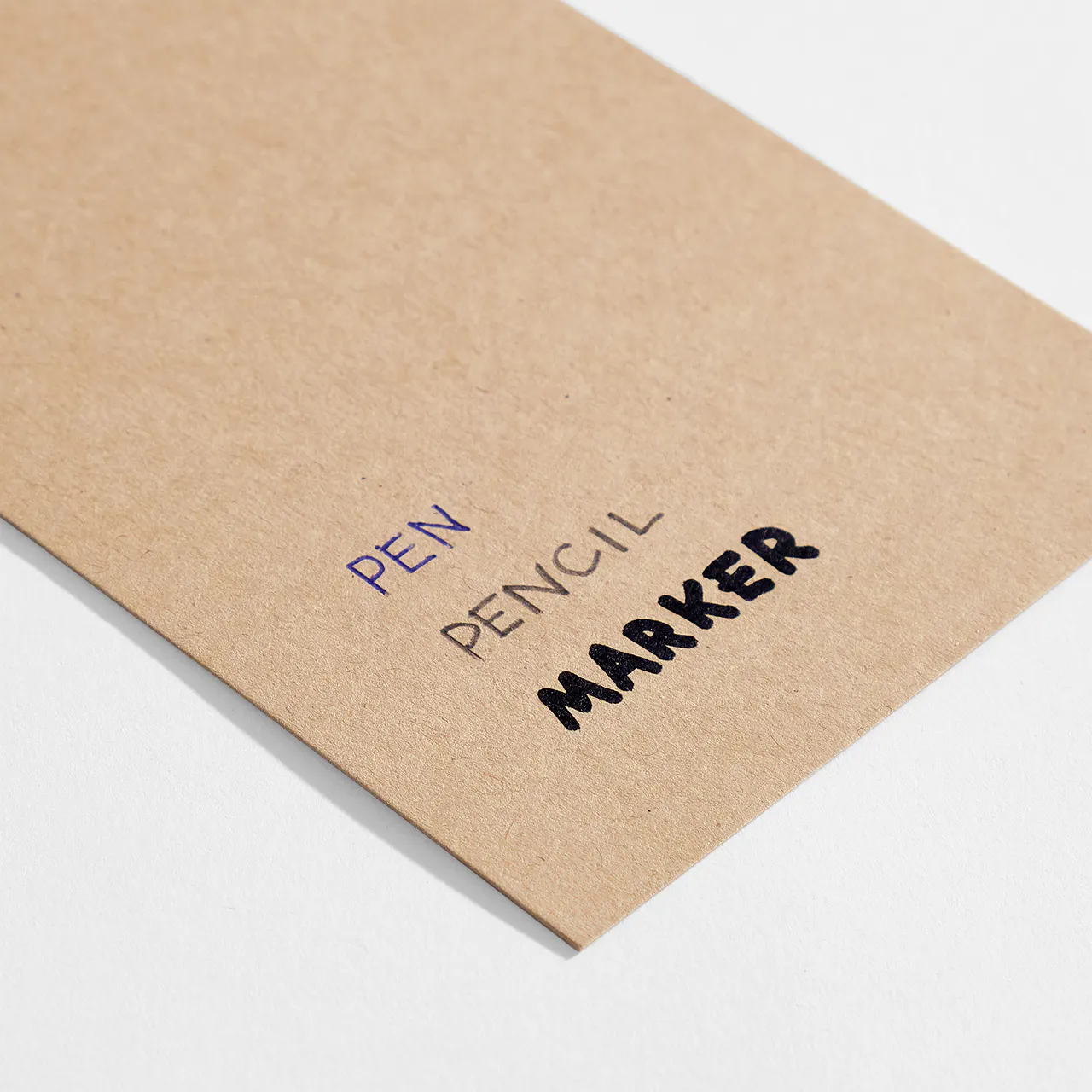 Kraft paper stock with pen, pencil and marker written on it.