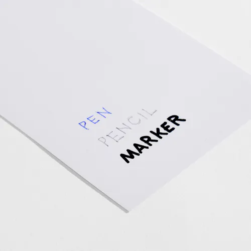 SOFT TOUCH LAMINATE Paper stock with Soft Touch laminate and pen, pencil and marker written on it.