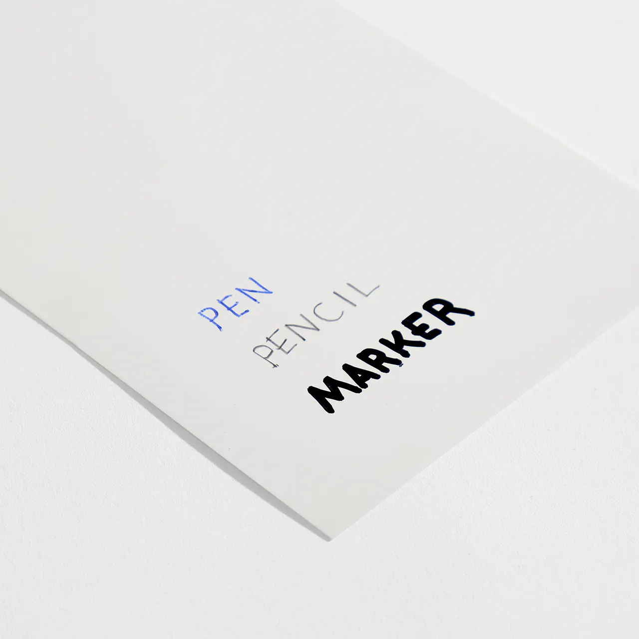 Synthetic waterproof paper stock with pen, pencil and marker written on it.