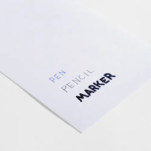 UNCOATED 100% RECYCLED Uncoated 100% recycled paper stock with pen, pencil and marker written on it.