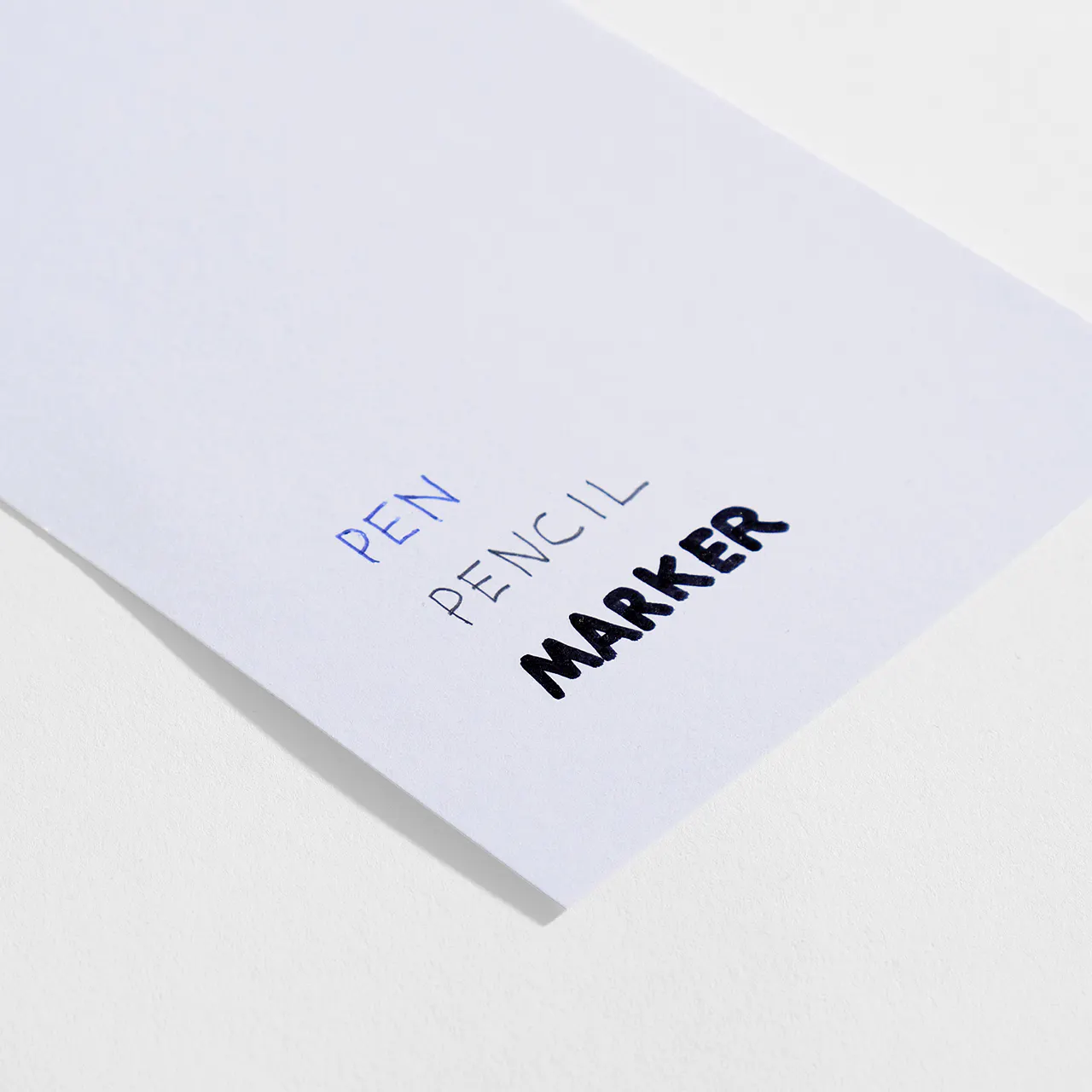 Uncoated smooth paper stock with pen, pencil and marker written on it.